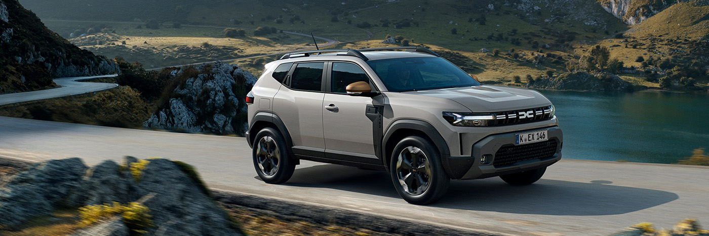 Ein moderner SUV fährt auf einer kurvigen Straße mit einer malerischen Landschaft im Hintergrund.