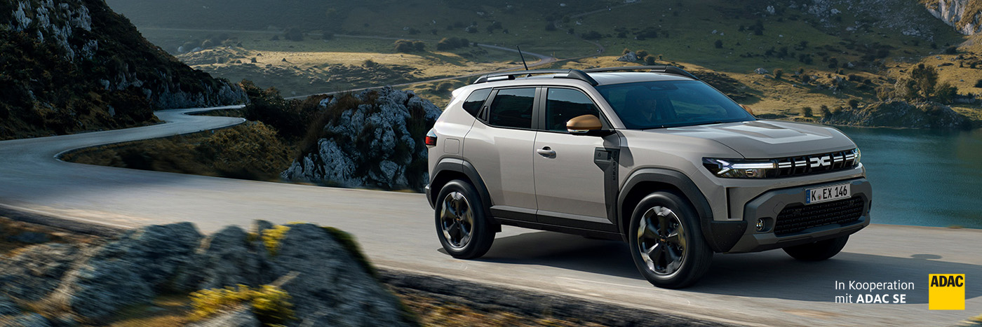 Ein SUV fährt auf einer kurvenreichen Straße durch eine malerische Landschaft.