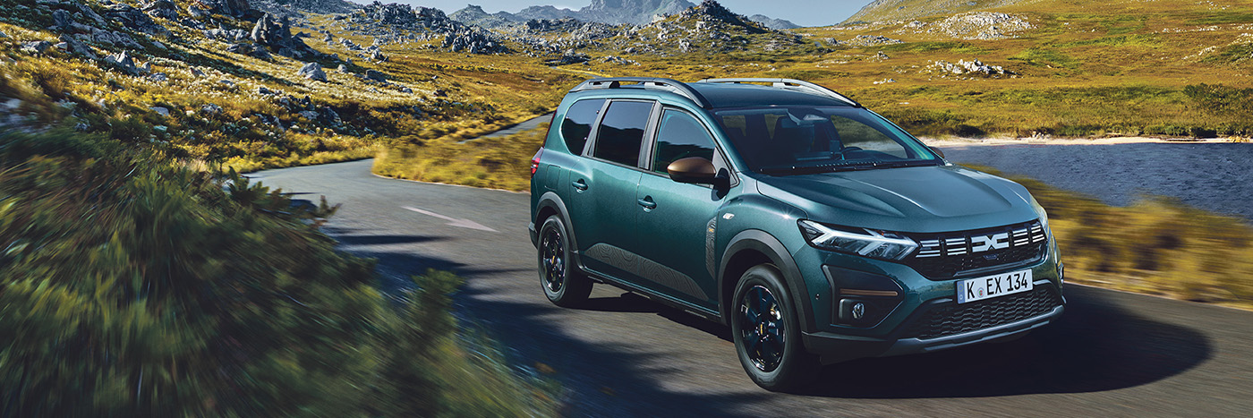 Ein moderner SUV in einem malerischen Landschaftssetting auf einer kurvenreichen Straße.