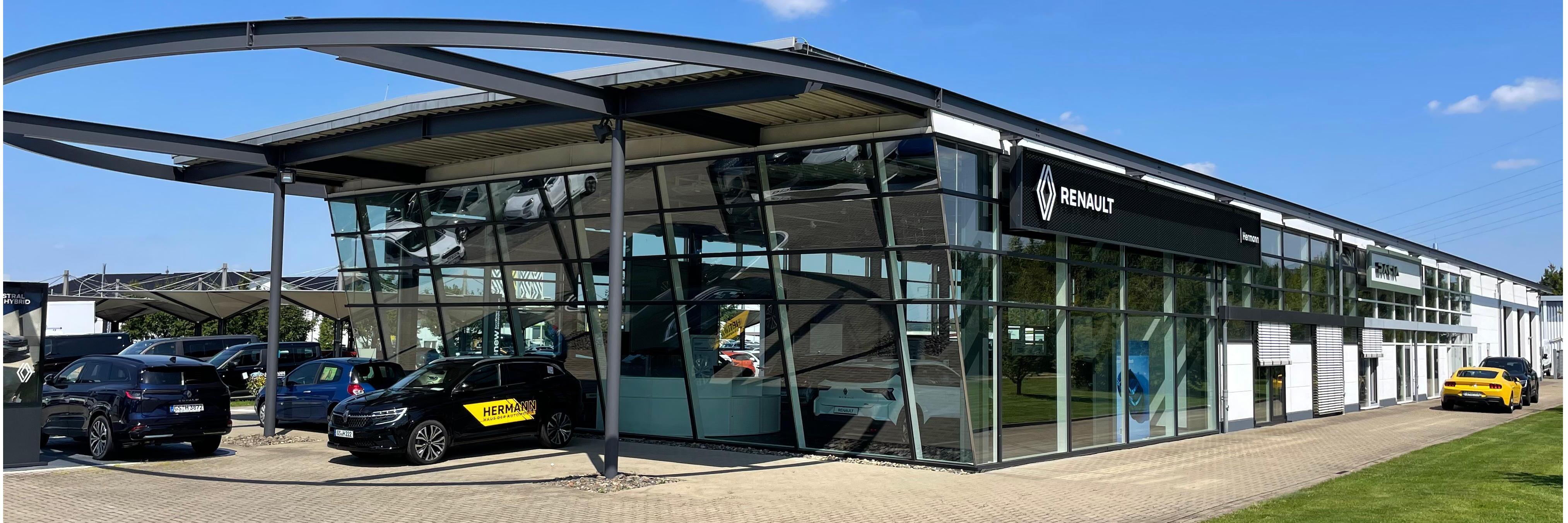 Renault Autohaus mit moderner Architektur, mehreren Fahrzeugen und großem Fensterbereich.