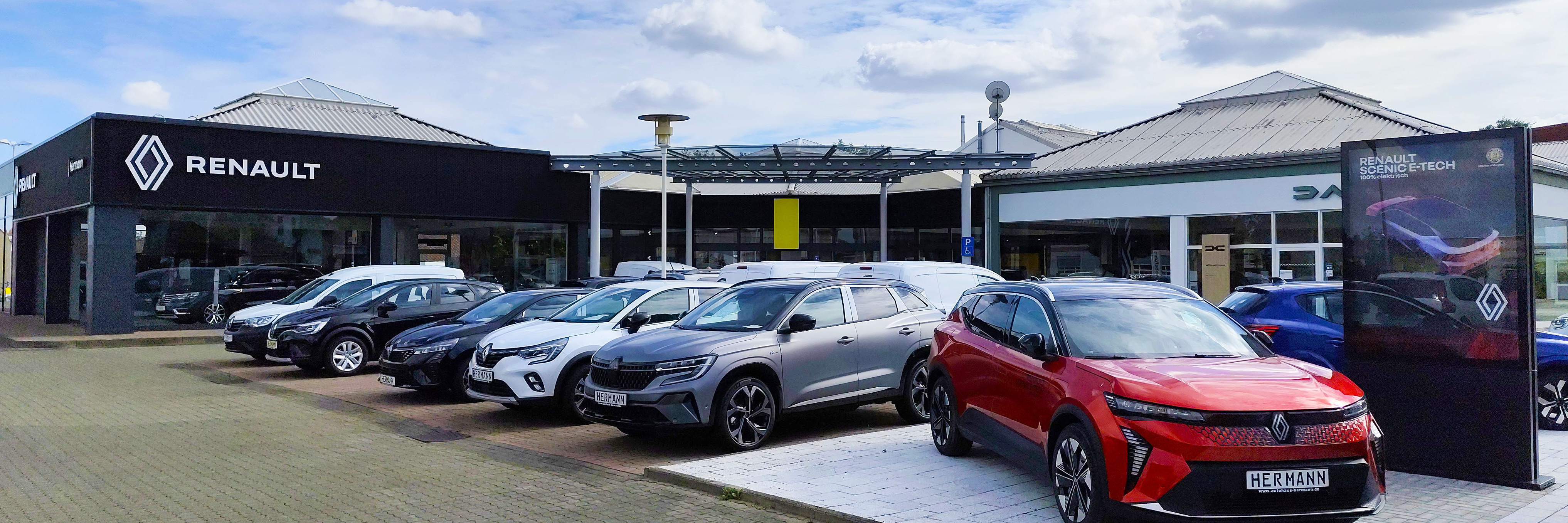 Renault Autohaus mit mehreren Fahrzeugen und einem großen Verkaufsraum im Hintergrund.