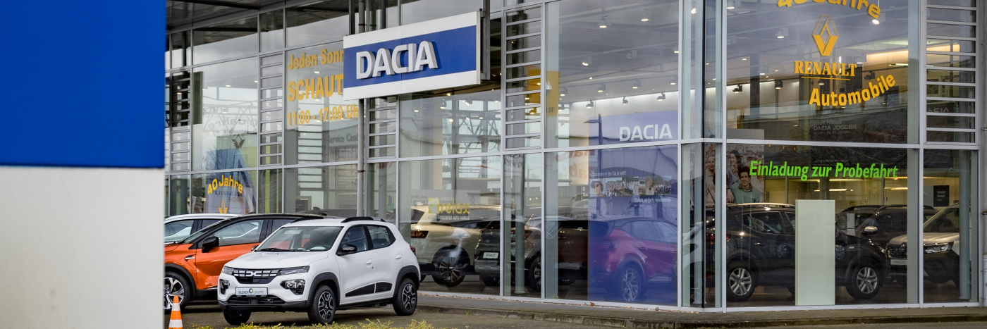Dacia Autohaus mit mehreren Autos im Verkaufsbereich und dem Hinweis zur Probefahrt.