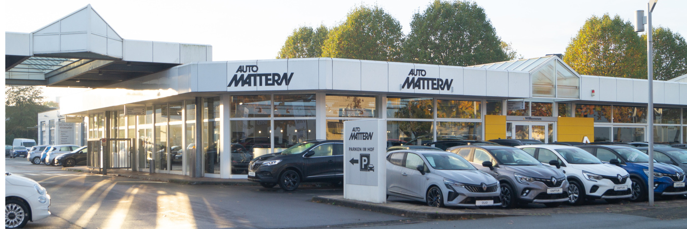 Auto Mattern Autohaus mit mehreren Fahrzeugen ausgestellt, im Hintergrund Bäume und ein klarer Himmel.