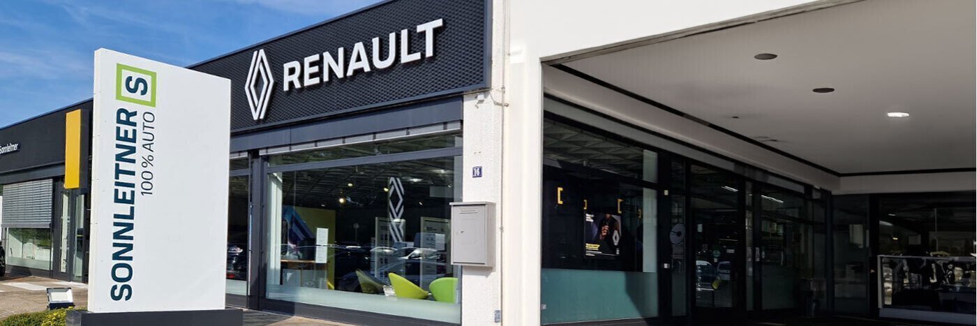 Renault Autohaus Sonnleitner mit modernem Design und großen Fenstern, sonniger Tag.